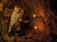 Eine Person entzündet ein Licht im Stollen.