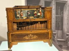 Eine Drehorgel aus Holz, darauf verschiedene Figuren.