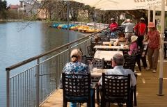 Café Seeterasse am Stadtrainsee: mehrere Menschen sitzen bei Sonnenschein am Seeufer